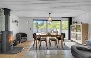 a dining room with a table and a fireplace at Amazing Home In Blåvand With Kitchen in Ho