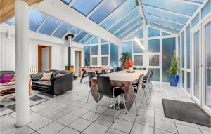 giardino d'inverno con sala da pranzo, tavolo e sedie di Pet Friendly Home In Blåvand With Wifi a Blåvand