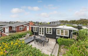 a house with a deck with a table and chairs at Awesome Home In Esbjerg V With 2 Bedrooms And Wifi in Hjerting