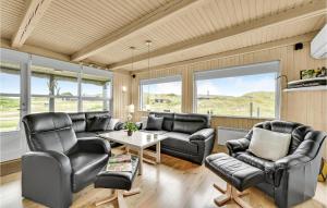 ein Wohnzimmer mit Ledermöbeln und großen Fenstern in der Unterkunft 4 Bedroom Lovely Home In Ringkbing in Søndervig