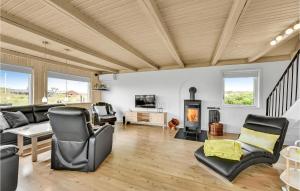 ein Wohnzimmer mit Möbeln und einem Kamin in der Unterkunft 4 Bedroom Lovely Home In Ringkbing in Søndervig
