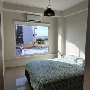 1 dormitorio con cama y ventana con piscina en Departamento con vista al rio en Posadas