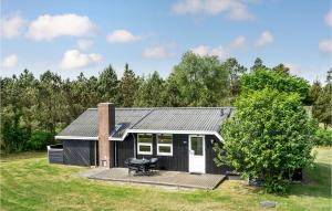 uma pequena casa a preto e branco com um deque em Amazing Home In Blvand With Wifi em Blåvand