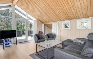 uma sala de estar com um sofá e uma televisão em Amazing Home In Blvand With Wifi em Blåvand