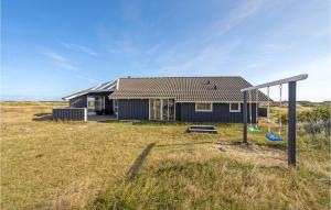 a house with a playground in a field at Holiday Home Arvidvej Denm in Bjerregård