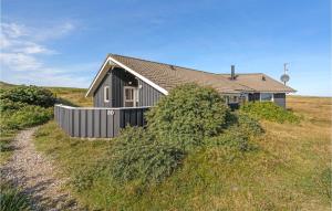 BjerregårdにあるStunning Home In Hvide Sande With Kitchenの草の丘の上に座る家