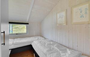 BjerregårdにあるStunning Home In Hvide Sande With Kitchenのベッドと窓が備わる小さな客室です。