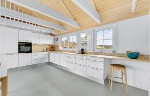 eine Küche mit weißen Schränken und einer Holzdecke in der Unterkunft Awesome Home In Ringkøbing With Sauna in Nørre Lyngvig