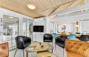 Zimmer mit Stühlen, einem Tisch und einem TV in der Unterkunft Awesome Home In Ringkøbing With Sauna in Nørre Lyngvig