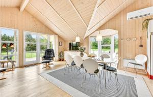 リンケビングにあるFour-Bedroom Holiday Home In Ringkobingのテーブルと椅子のあるダイニングルーム