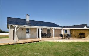 a house with a deck with chairs and a table at Awesome Home In Harboøre With Kitchen in Harboør