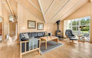 リンケビングにあるFour-Bedroom Holiday Home In Ringkobingのソファと暖炉のあるリビングルーム