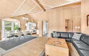 リンケビングにあるFour-Bedroom Holiday Home In Ringkobingのリビングルーム(黒い革張りのソファ、テーブル付)