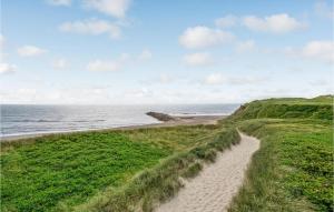 a dirt road leading to a beach next to the ocean at Three-Bedroom Holiday Home In Lemvig in Trans +20 photos