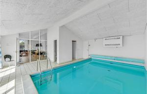una piscina con agua azul en una habitación en Awesome Home In Ringkbing With Indoor Swimming Pool, en Klegod