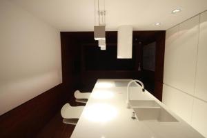een keuken met een wit aanrecht en 2 witte stoelen bij Modern & Resto Apartments in Krakau