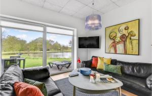 uma sala de estar com um sofá e uma mesa em Awesome Home In Ringkbing With House Sea View em Hee