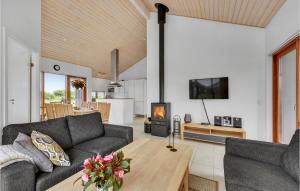 ThorsmindeにあるAmazing Home In Ulfborg With 3 Bedrooms And Wifiのリビングルーム(ソファ、テーブル付)