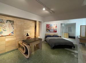 a bedroom with a bed and a desk and a tv at Vouliagmeni Art Micro Loft in Athens