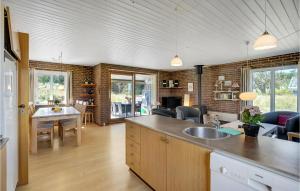 a kitchen and living room with a table and chairs at Holiday Home Clemmessti in Klitmøller