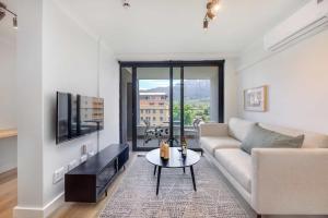 a living room with a couch and a table at Newlands Peak Aparthotel by Totalstay in Cape Town