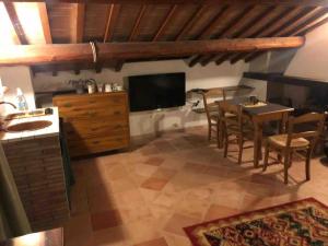 cocina y comedor con mesa y TV en Casale San Michèle, en Gubbio