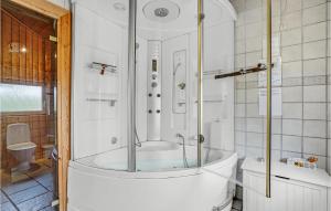 a bath tub with a shower in a bathroom at Holiday Home Tranebærvej Tarm Xi in Hemmet +19 photos