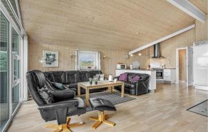 a living room with black leather furniture and a table at Holiday Home Tranebærvej Tarm Xi in Hemmet