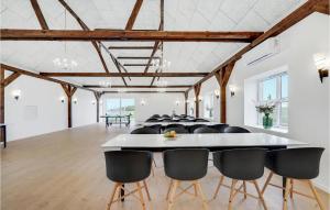 Cette grande chambre comprend une table et des chaises blanches. dans l'établissement Awesome Home In Grindsted With Kitchen, à Grindsted