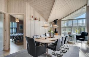 a dining room and living room with a table and chairs at Holiday Home Bellisvænget Hemmet Denm in Falen