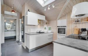 a large kitchen with white cabinets and appliances at Holiday Home Bellisvænget Hemmet Denm in Falen