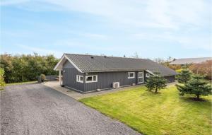 a grey house with a gravel driveway at Holiday Home Bellisvænget Hemmet Denm in Falen +18 photos