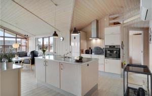 an open kitchen with white cabinets and a living room at Nice Home In Hemmet With 4 Bedrooms, Sauna And Wifi in Hemmet