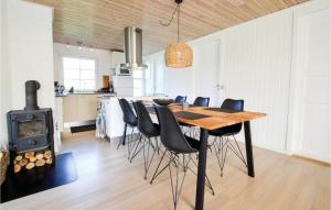a kitchen and dining room with a wooden table and chairs at Hygihytten in Hemmet