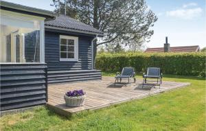 two chairs on a wooden deck next to a house at Hygihytten in Hemmet