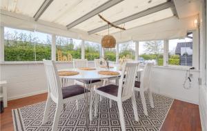 a dining room with a white table and chairs at Hygihytten in Hemmet