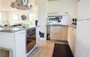 a kitchen with a sink and a stove top oven at Hygihytten in Hemmet