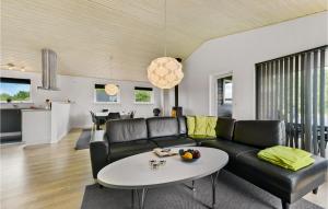 FalenにあるStunning Home In Hemmet With 3 Bedrooms, Sauna And Wifiのリビングルーム(黒いソファ、テーブル付)