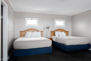 a hotel room with two beds and two windows at Admiral Motel in Lake George