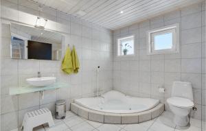 un bagno con vasca, lavandino e WC di Four-Bedroom Holiday Home In Tarm a Tarm Altre 33 foto