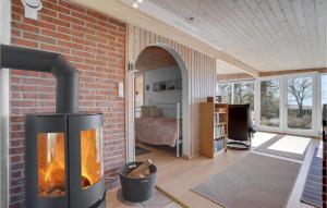 a fireplace in a living room with a brick wall at Awesome Home In Roslev With Kitchen in Roslev