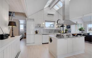 una cucina con mobili bianchi e un forno a piano cottura di Four-Bedroom Holiday Home In Tarm a Tarm