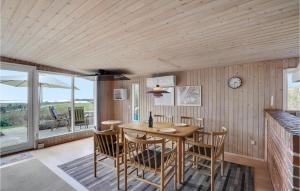 a dining room with a wooden table and chairs at Awesome Home In Roslev With Kitchen in Roslev