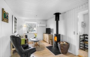 ThyholmにあるStunning Home In Thyholm With 3 Bedrooms, Sauna And Wifiのリビングルーム(暖炉、テーブル付)