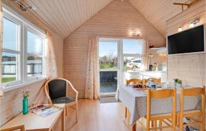 eine kleine Küche und ein Esszimmer mit einem Tisch und Stühlen in der Unterkunft Amazing Home In Struer With Kitchen in Remmer Strand