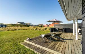 a deck with a table and chairs and an umbrella at 3 Bedroom Beautiful Home In Vestervig in Vestervig