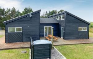 a black tiny house on a wooden deck at Nice Home In Hurup Thy With House A Panoramic View in Sindrup