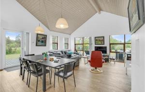 a dining room and living room with a table and chairs at Holiday Home Skovvej Thyholm Xii in Thyholm