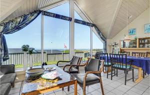 ein Wohnzimmer mit einem Tisch und Stühlen sowie einem großen Fenster in der Unterkunft Beautiful Home In Struer With House Sea View in Struer