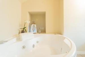 a white bath tub in a bathroom with a mirror at Romantic Escape city centre with Jacuzzi & Parking by Rent All Como in Como